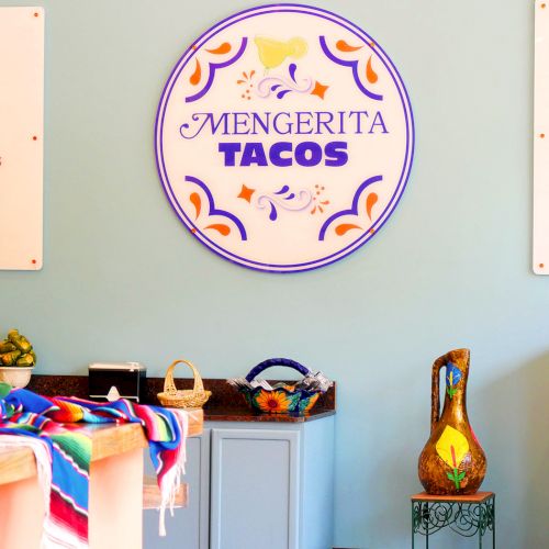 A classroom scene with kids seated at desks while a teacher demonstrates at the front, colorful posters and a globe nearby.